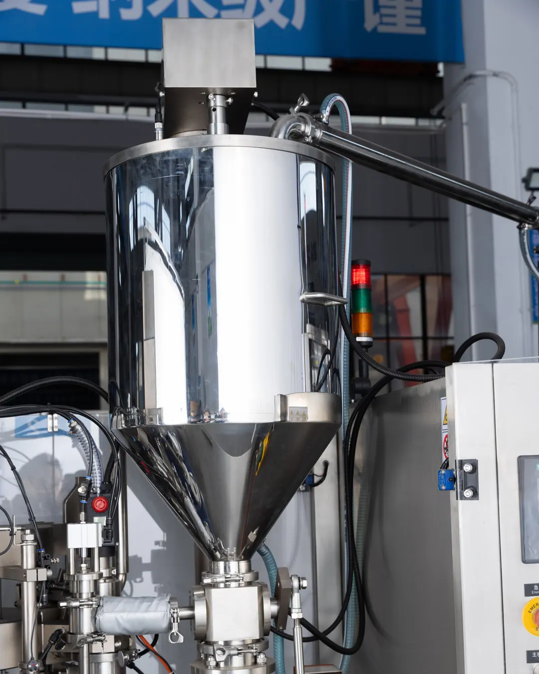 High-viscosity veterinary paste entering a stainless-steel transfer hopper