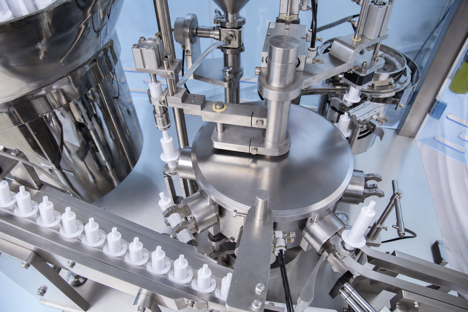 White intramammary syringes indexed on the filling machine conveyor